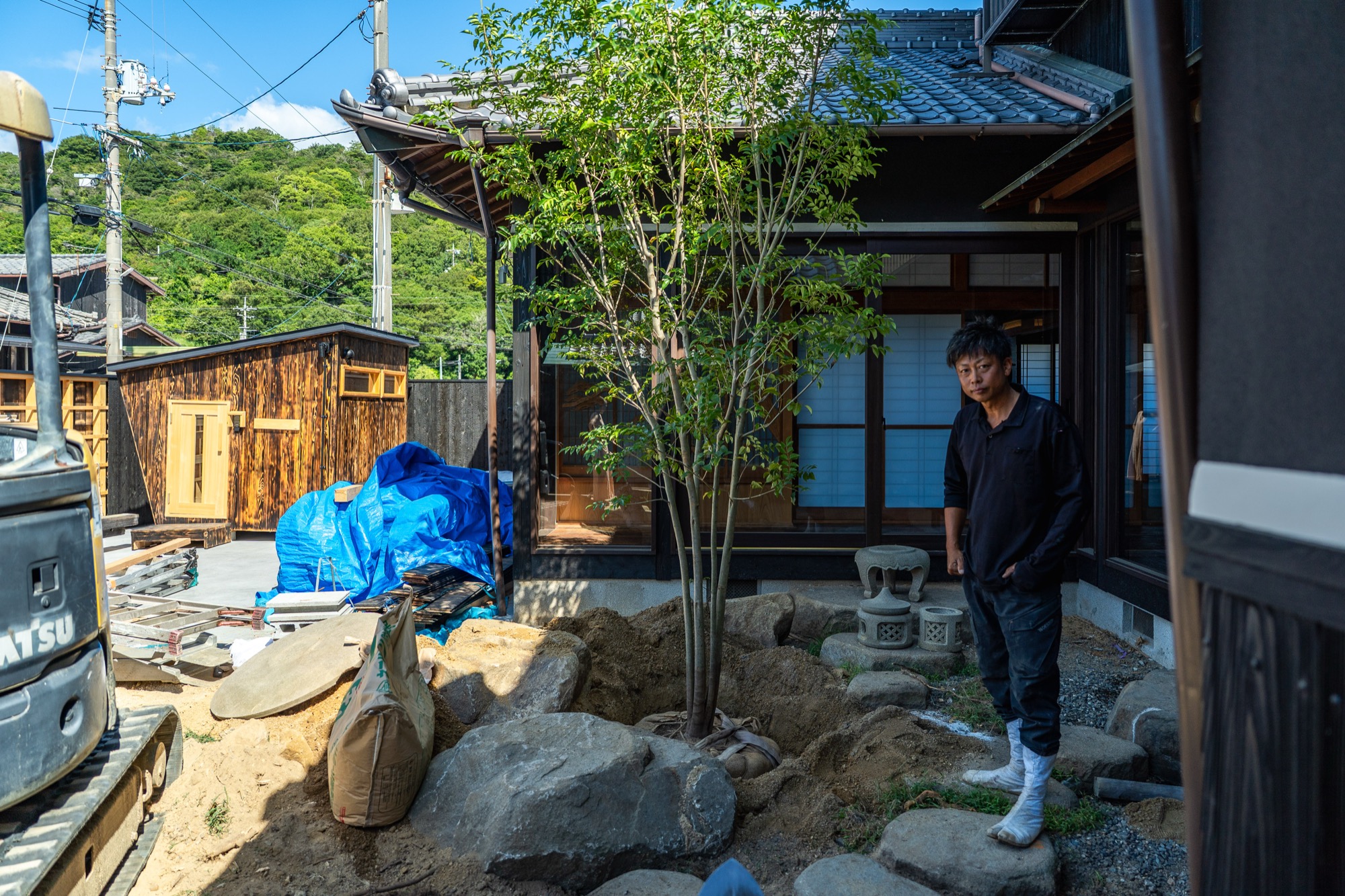 仕上がった苔と石の庭を眺める、職人の後ろ姿
